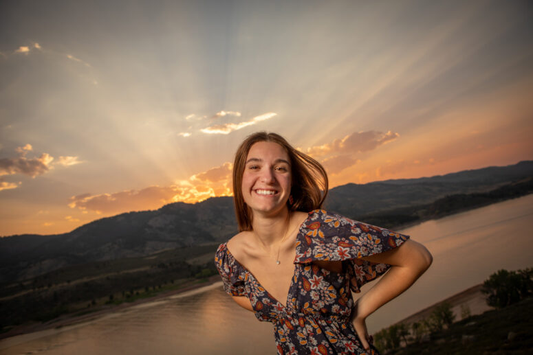 Sun sets over Fort Collins while girl smiles.